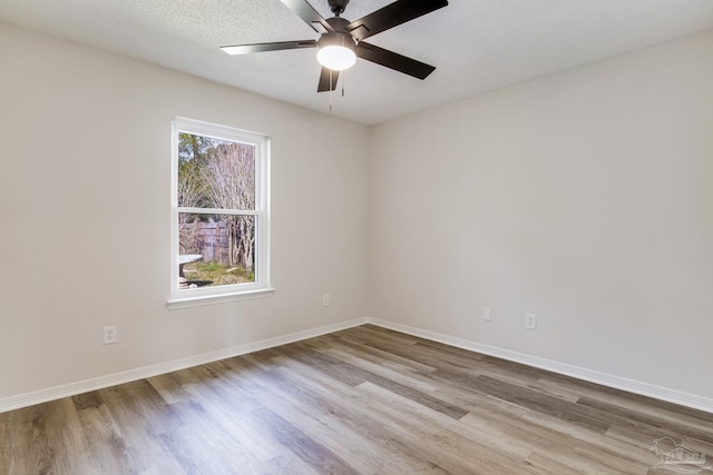 unfurnished room featuring a ceiling fan, a textured ceiling, baseboards, and wood finished floors