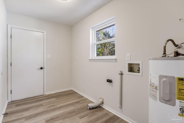 washroom featuring light wood-style flooring, hookup for an electric dryer, electric water heater, laundry area, and baseboards