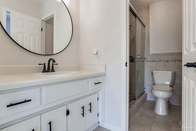 full bath with tile patterned flooring, tile walls, a shower stall, and toilet