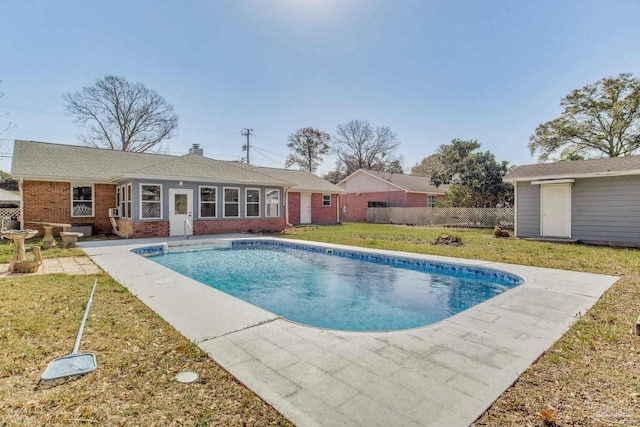 view of pool featuring a yard, an outdoor structure, fence, and a fenced in pool