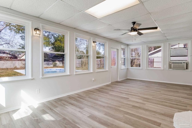 unfurnished sunroom featuring a healthy amount of sunlight, a paneled ceiling, and cooling unit