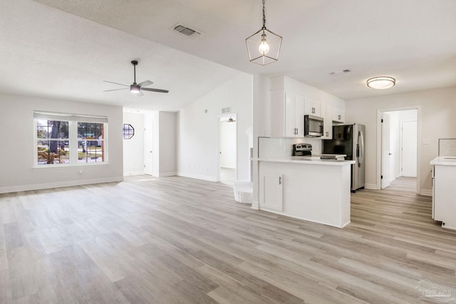 kitchen with visible vents, white cabinets, open floor plan, stainless steel appliances, and light countertops