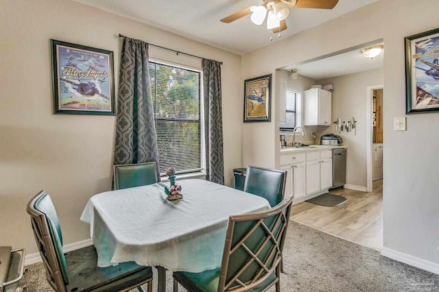 dining area with light hardwood / wood-style flooring, ceiling fan, and sink