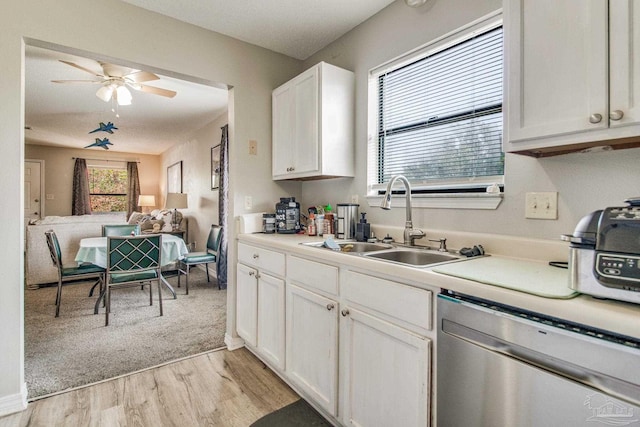 kitchen featuring ceiling fan, sink, light hardwood / wood-style flooring, stainless steel dishwasher, and white cabinets