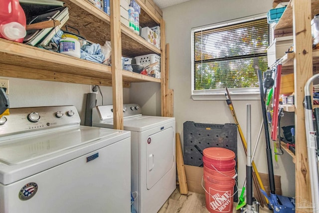 laundry room with separate washer and dryer and light hardwood / wood-style flooring