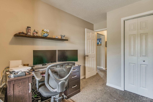 carpeted home office featuring a textured ceiling