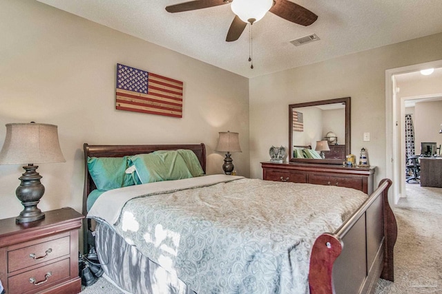 carpeted bedroom with ceiling fan and a textured ceiling