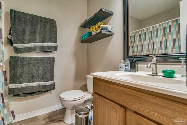 bathroom with vanity, toilet, a textured ceiling, walk in shower, and wood-type flooring