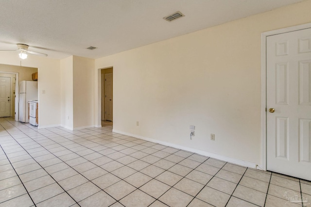 tiled spare room featuring a textured ceiling and ceiling fan