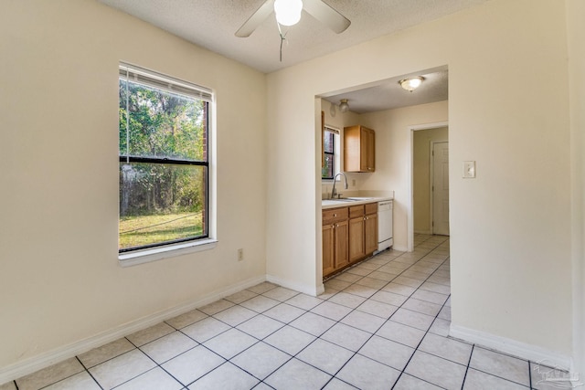 kitchen with light tile patterned floors, a textured ceiling, ceiling fan, and sink