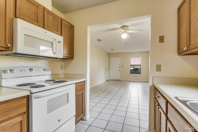 kitchen with a textured ceiling, white appliances, ceiling fan, sink, and light tile patterned flooring