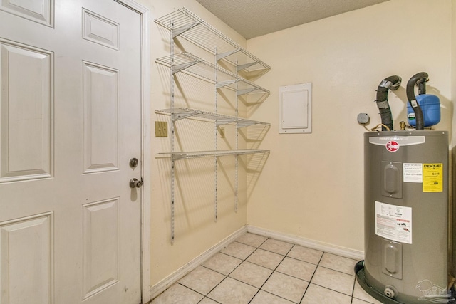 utility room featuring electric panel and water heater