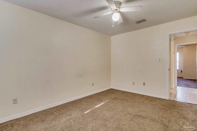 unfurnished room with a textured ceiling, carpet floors, and ceiling fan