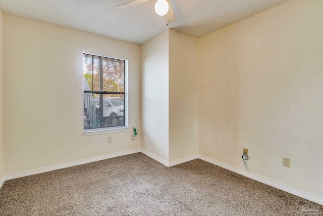 carpeted spare room featuring ceiling fan and a textured ceiling