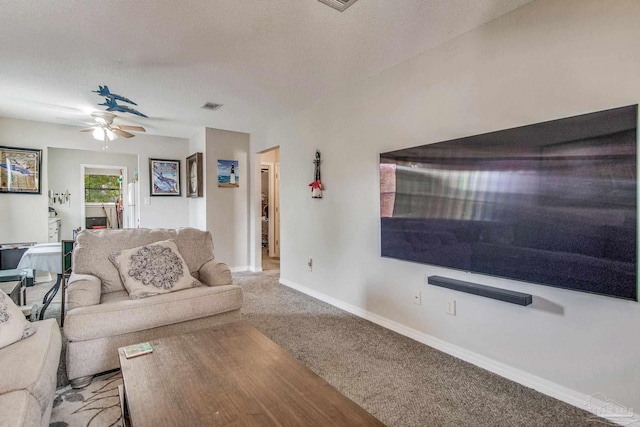 living room featuring light carpet, ceiling fan, and a textured ceiling