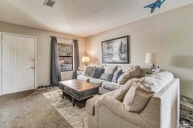 carpeted living room featuring a textured ceiling