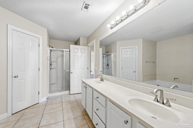 bathroom featuring vanity, shower with separate bathtub, a textured ceiling, and tile patterned floors