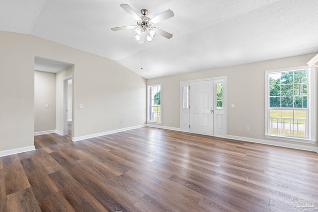 unfurnished living room with a healthy amount of sunlight, dark hardwood / wood-style flooring, and lofted ceiling