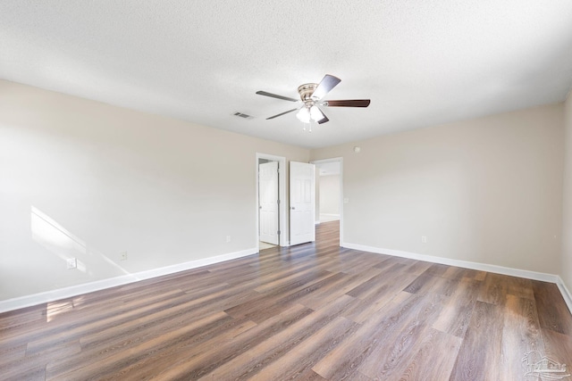 spare room with a textured ceiling, ceiling fan, and dark hardwood / wood-style floors