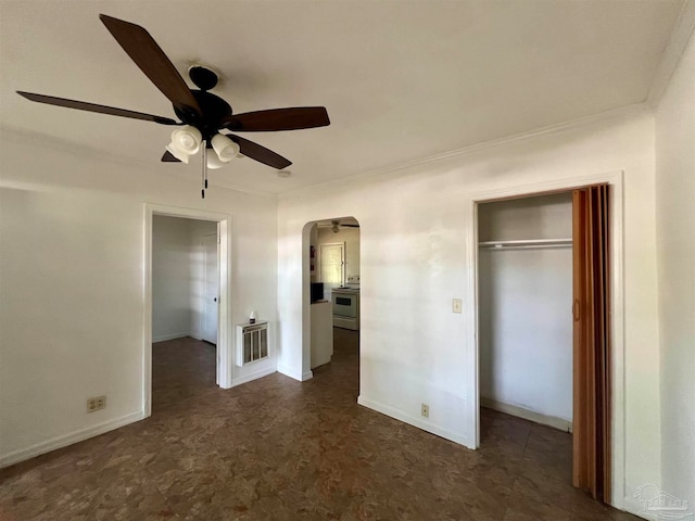 unfurnished bedroom with dark tile patterned floors, a closet, and ceiling fan