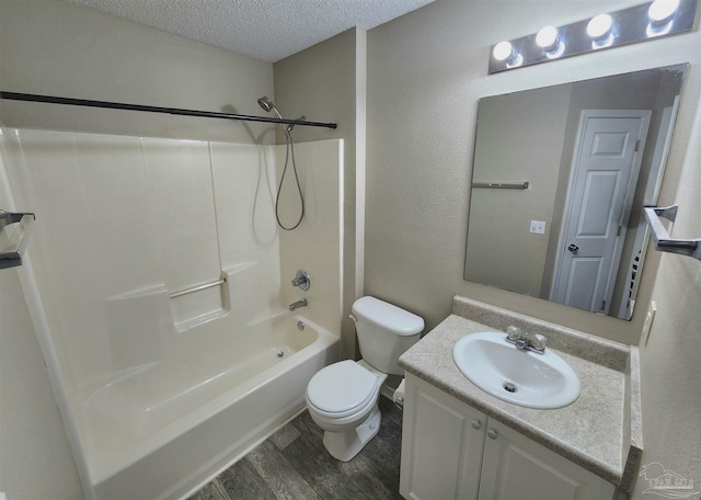 full bath with toilet, tub / shower combination, vanity, a textured ceiling, and wood finished floors