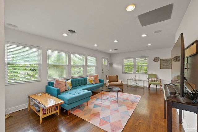 living room with dark wood-type flooring and a wealth of natural light