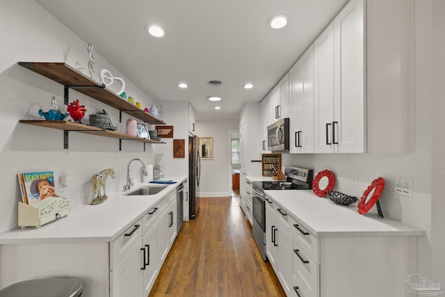 kitchen featuring dark hardwood / wood-style flooring, sink, white cabinets, and appliances with stainless steel finishes