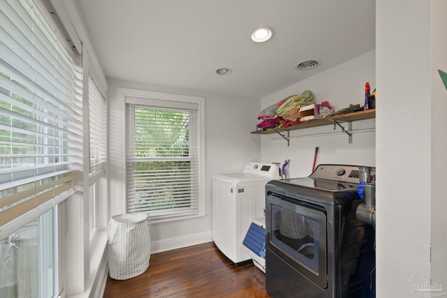 clothes washing area with washer and dryer and dark hardwood / wood-style flooring