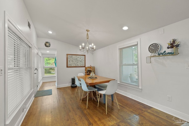 dining area featuring dark hardwood / wood-style flooring, lofted ceiling, and a chandelier