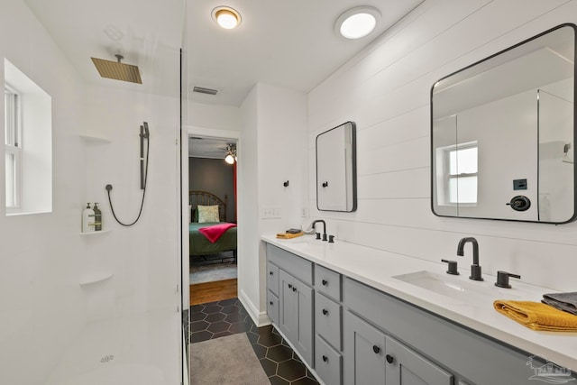 bathroom with tile patterned flooring, vanity, and walk in shower