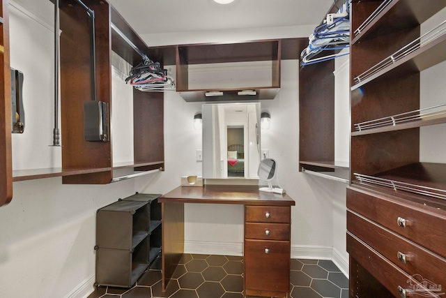 spacious closet with dark tile patterned floors