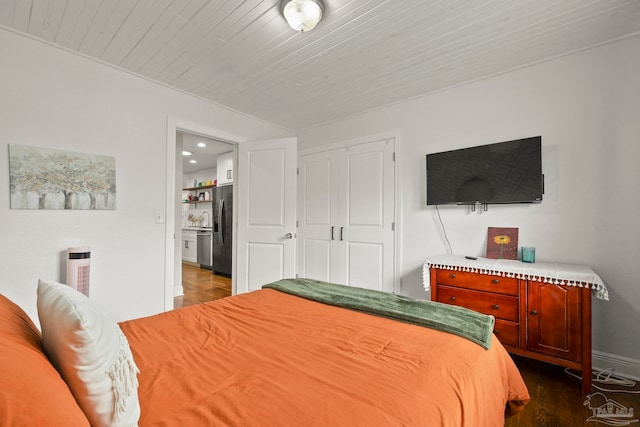 bedroom featuring stainless steel fridge, dark hardwood / wood-style flooring, and a closet