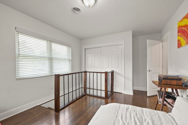 bedroom with a closet and dark wood-type flooring