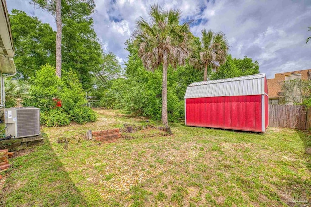 view of yard with central AC unit and a storage shed