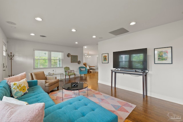 living room featuring dark wood-type flooring and a notable chandelier