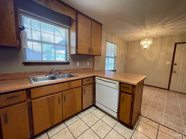 kitchen with a healthy amount of sunlight, sink, dishwasher, kitchen peninsula, and pendant lighting