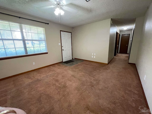 carpeted empty room with a textured ceiling and ceiling fan