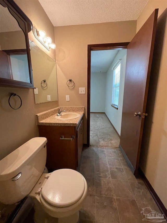 bathroom with vanity, a textured ceiling, toilet, and tile patterned floors