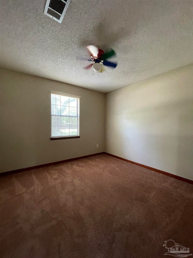 carpeted spare room with a textured ceiling and ceiling fan