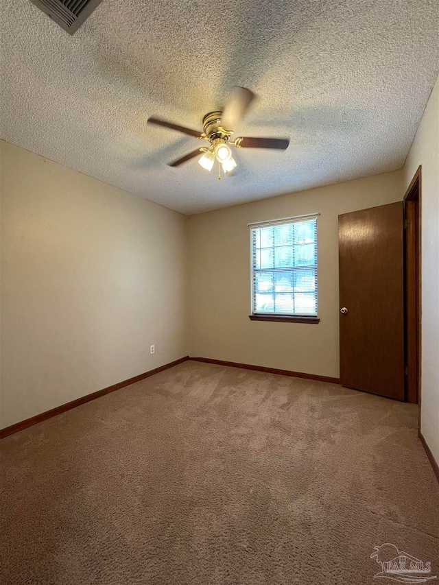 spare room featuring carpet, ceiling fan, and a textured ceiling