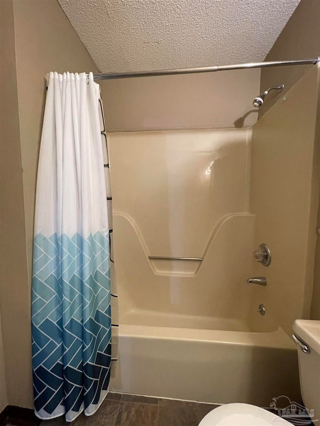 bathroom featuring toilet, a textured ceiling, shower / bath combo with shower curtain, and tile patterned floors