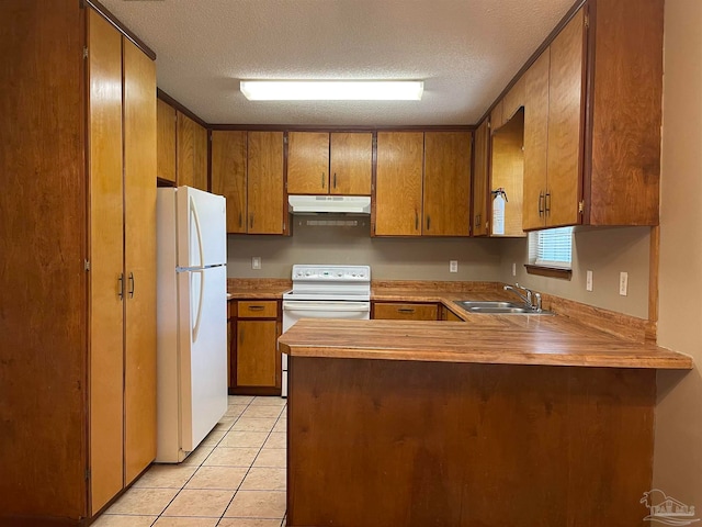 kitchen featuring white appliances, sink, a textured ceiling, kitchen peninsula, and light tile patterned floors