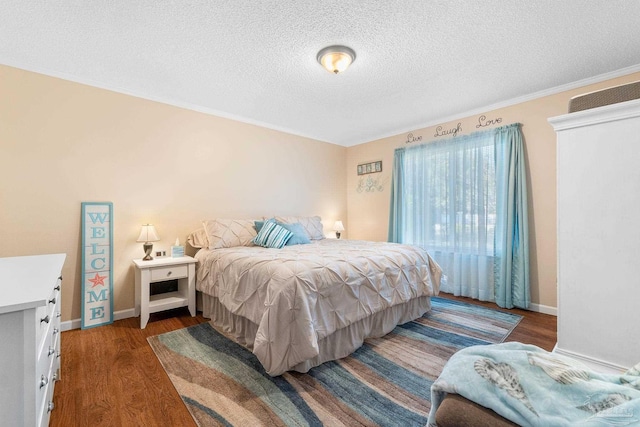 bedroom with a textured ceiling, dark hardwood / wood-style flooring, and ornamental molding