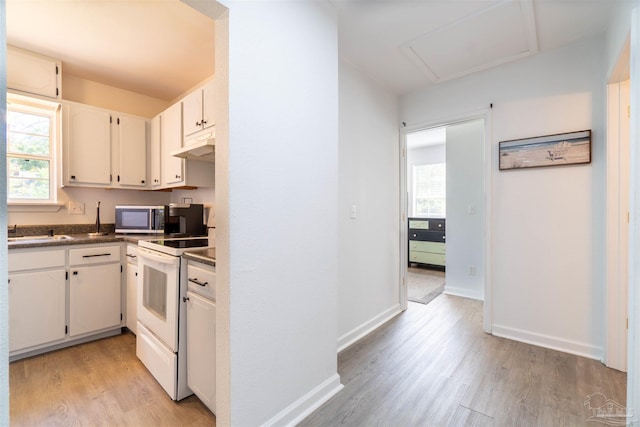 kitchen with white electric range, light hardwood / wood-style flooring, sink, and white cabinets