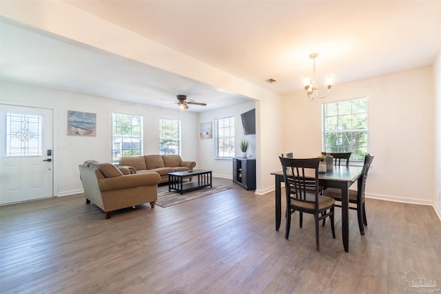 dining area featuring dark hardwood / wood-style floors, ceiling fan with notable chandelier, and a wealth of natural light