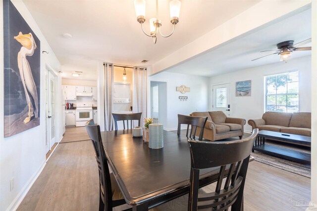 dining space with light hardwood / wood-style floors and ceiling fan with notable chandelier