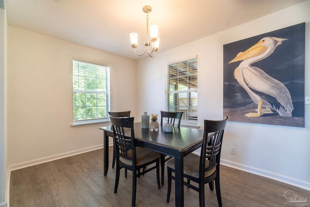 dining space featuring dark hardwood / wood-style flooring and an inviting chandelier