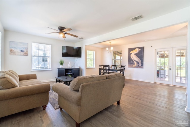 living room featuring ceiling fan with notable chandelier, hardwood / wood-style floors, and plenty of natural light