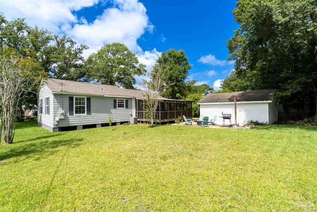 back of property with a yard and an outdoor structure