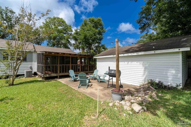 rear view of house featuring a patio, central AC unit, a sunroom, and a lawn